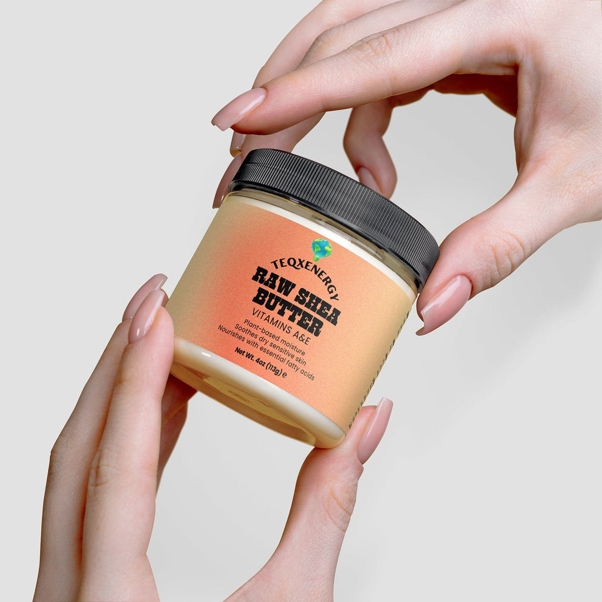 TeqenX Raw Shea Butter jar held in hands, featuring a black lid and label highlighting Vitamins A & E for natural skincare.
